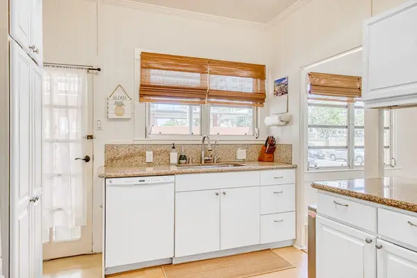 White kitchen features ample cabinetry and generous counter space