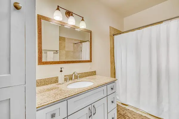 Full bathroom offers a shower and tub combination with bright vanity lighting