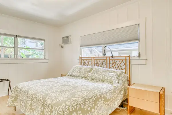King bedroom features soft bedding and bright corner windows