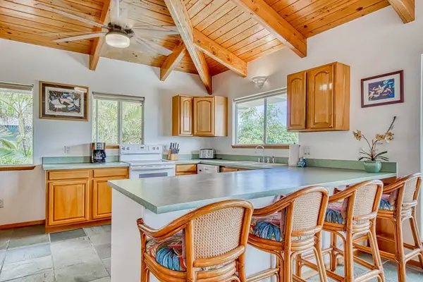 Fully equipped kitchen with island bar seating and vaulted ceilings