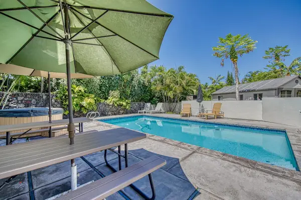Sparkling swimming pool with lounge chairs and shaded seating