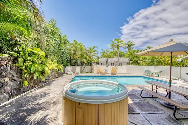 Resort outdoor pool & hot tub surrounded by tropical greenery