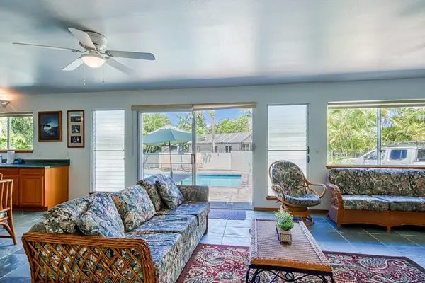 Comfortable Sofa Seating, Coffee Table, Ceiling Fan & Direct Pool Views