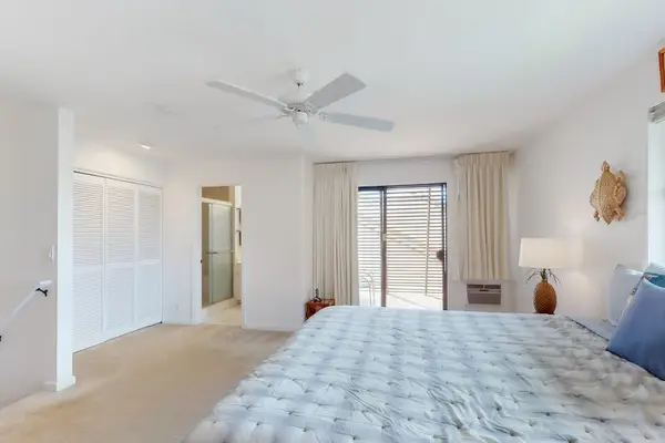 Features king bed, ceiling fan, and balcony access
