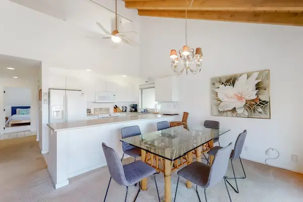 Dining table and chairs brighten open kitchen space beside windows