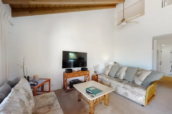 Living room seating and television overlook lush tropical garden scenery