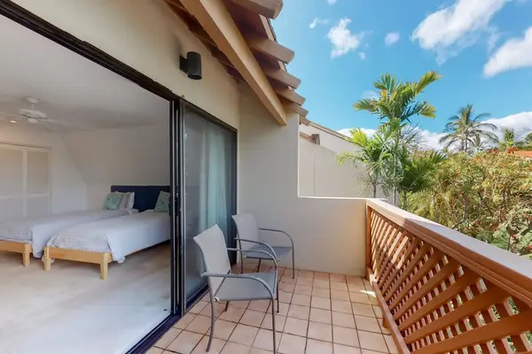 Balcony seating frames palms, sliding doors, and breezy island views