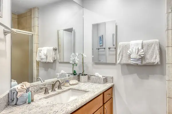 Full Bathroom vanity features wood cabinetry wide counters and mirrors