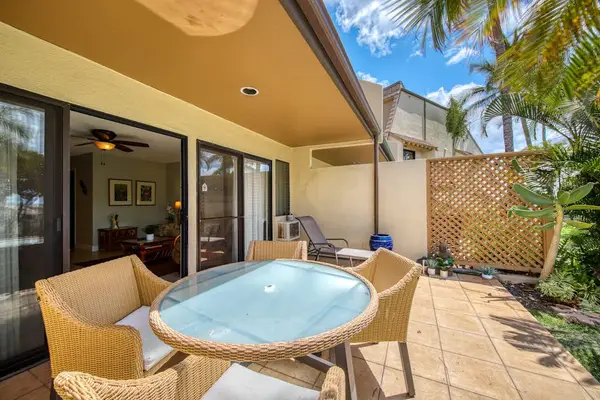 Covered patio dining offers relaxed seating beside tropical greenery outdoors