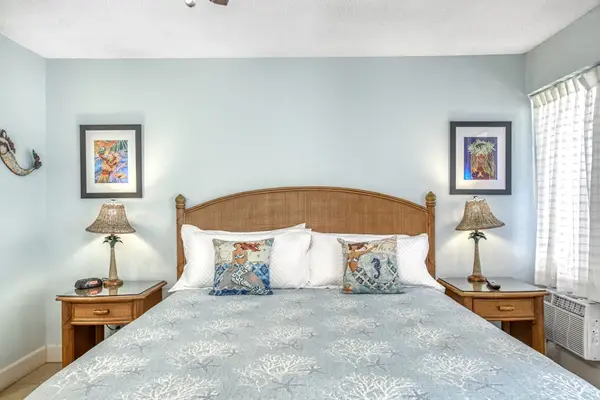 Bedroom opens toward balcony with bedding and ceiling fan