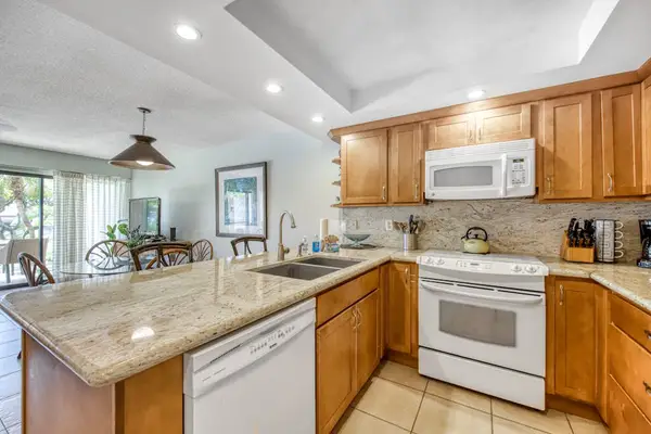 Kitchen view reveals granite counters living room and garden beyond