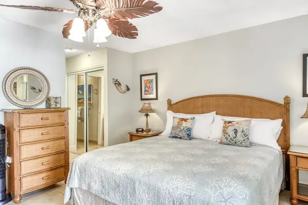 Showcases king bed nightstands artwork and tropical details