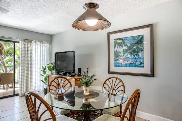 Rattan dining table welcomes meals beside kitchen and garden views