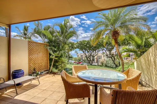 Covered patio dining area pairs seating with tropical garden views
