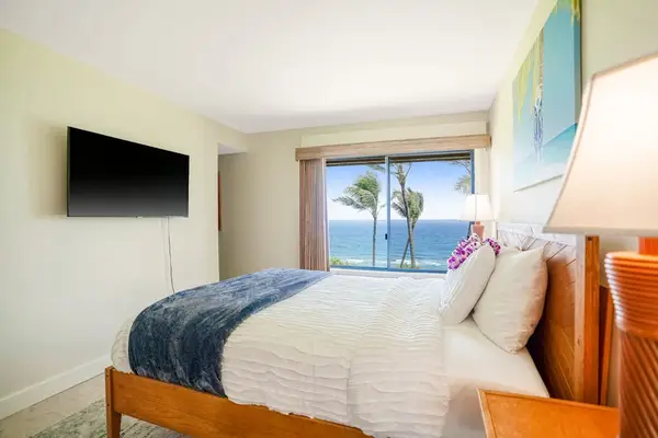 Comfortable master bedroom equipped with a flat-screen TV and scenic window views
