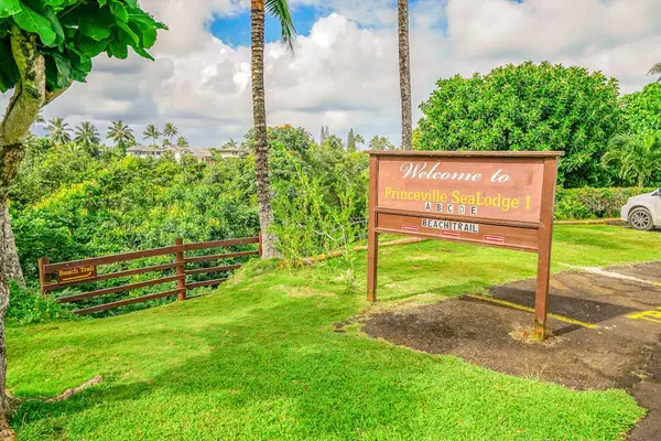 Welcome entrance sign surrounded by lush tropical greenery at Sealodge