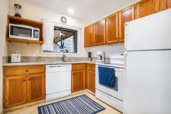 Fully equipped kitchen with wooden cabinetry and modern appliances