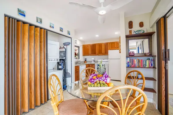 Dining table with wicker seating and views leading into the kitchen