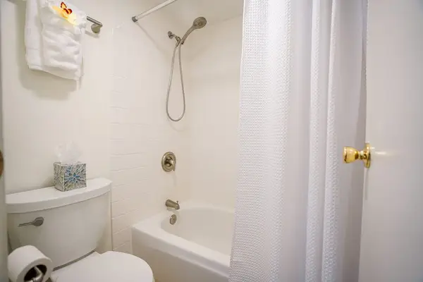 Clean, full bathroom featuring a tub-shower combo and fresh amenities