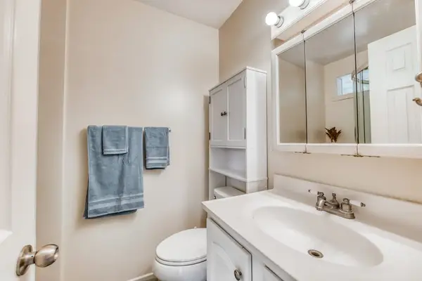 Clean Vanity & Toilet Area with White Cabinetry & Fresh Towels