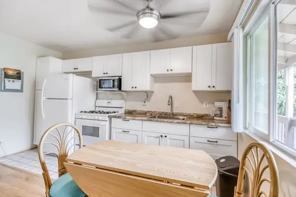 Fully Equipped Kitchen with White Cabinetry & Small Dining Table Setup