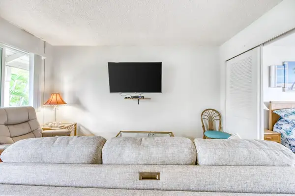 Open Living Room View showing Sofa, Wall TV & Sliding Bedroom Doors