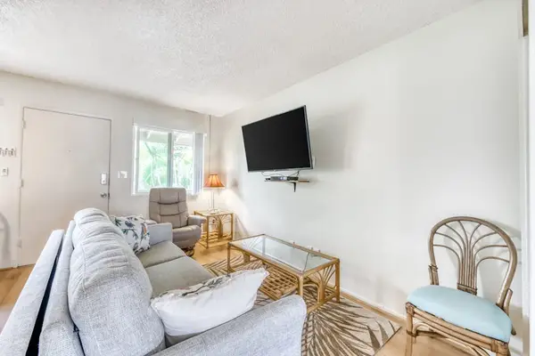 Bright Living Area with Comfortable Sofa, Wall-Mounted TV & Accent Seating