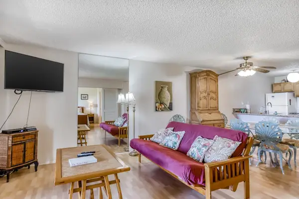 Open living room offers comfortable seating television and tropical views