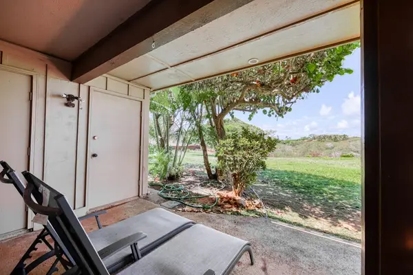 Covered lanai offers peaceful island views across green resort grounds