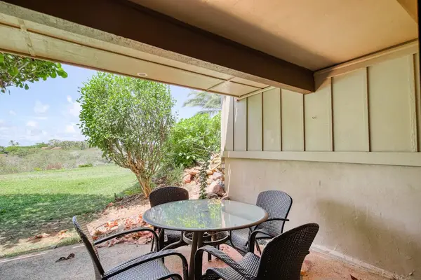 Covered patio provides outdoor seating beside peaceful resort grounds