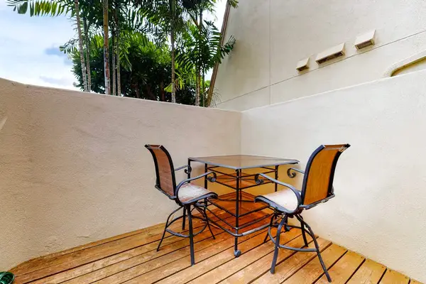 Outdoor dining table creates an inviting setting beside tropical landscaping