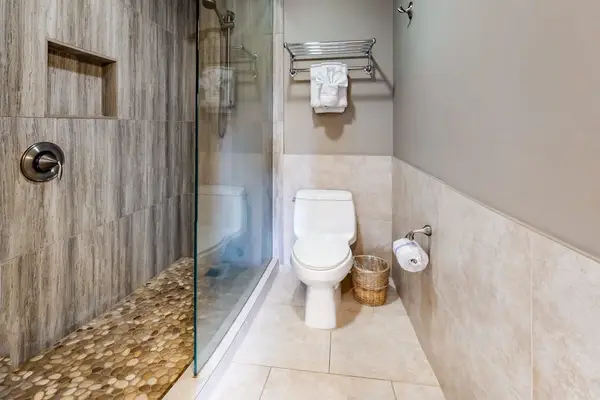 Bathroom shower and toilet area provide clean guest convenience daily