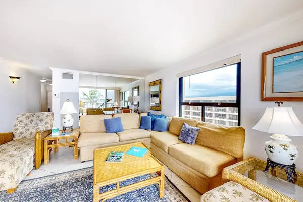 This large living room with a comfortable sectional with views from the open sliders of the lanai.  Turquoise waters as far as the eye could see.