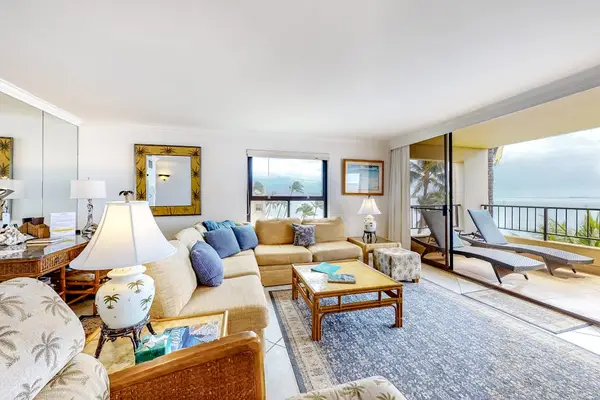 This large living room with a comfortable sectional with views from the open sliders of the lanai.  Turquoise waters as far as the eye could see.
