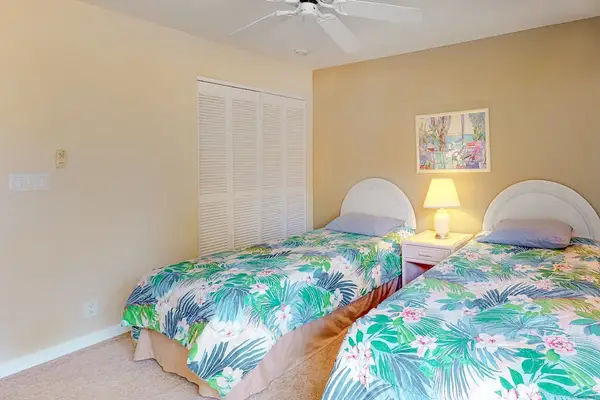 Second bedroom offers twin beds ceiling fan and convenient storage