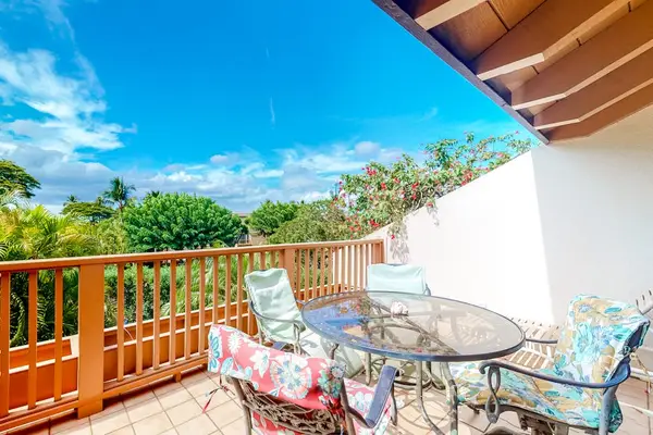 Balcony seating invites morning coffee beside tropical greenery and breezes