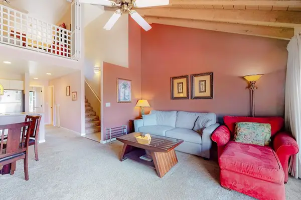 Living room offers colorful seating television and open island-style layout