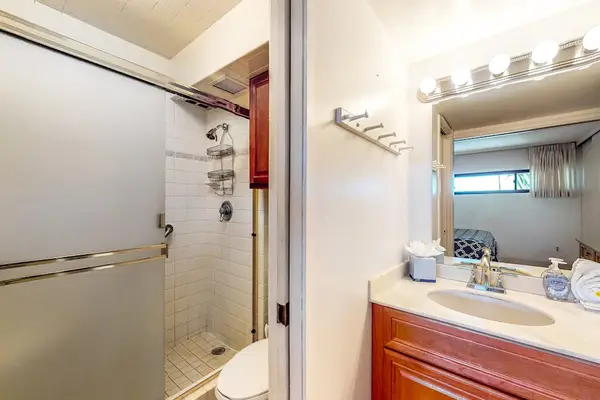 Walk-in shower with a frosted glass sliding door and single vanity.