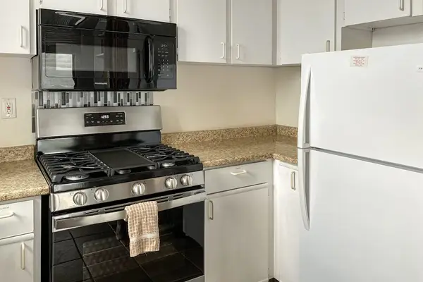 Convenient kitchen appliances, including a refrigerator, stove, and microwave, make meal preparation simple during your stay
