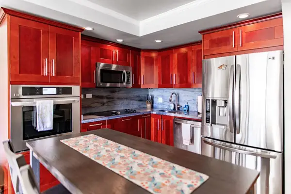 Modern fully equipped kitchen with stainless steel appliances, wood countertops, and everything needed for home-cooked meals.