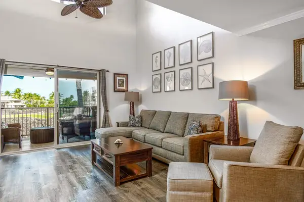 Living room filled with streaming light entering from the glass doors of the lanai.