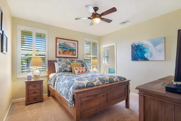 Cozy queen bedroom with ceiling fan and natural light
