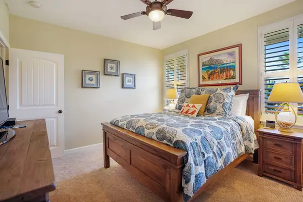 Queen bedroom featuring tropical décor and a comfortable bed