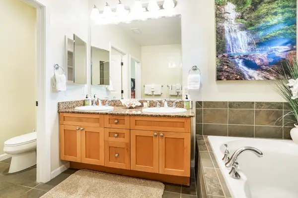 Dual vanity ensuite bathroom with a soaking tub, connected to the King bedroom