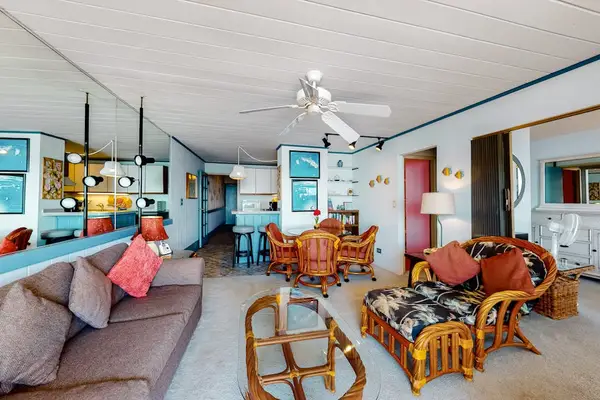 Bright living room with sliding glass doors, abundant natural light, and a comfortable sofa bed for extra guests.