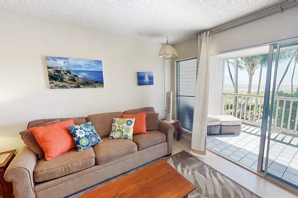 Bright living room offers comfortable seating and oceanview balcony access