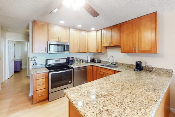 Kitchen features wood cabinetry granite counters and stainless steel appliances