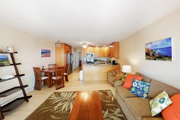 Open dining area features wooden table and colorful tropical artwork