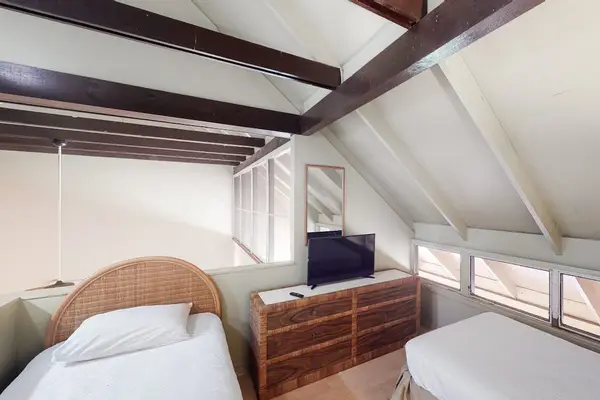 Second bedroom features twin beds lamps and bright natural light