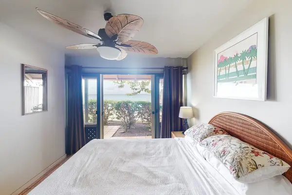 First bedroom with queen bed, ceiling fan, outdoor access, and beautiful views